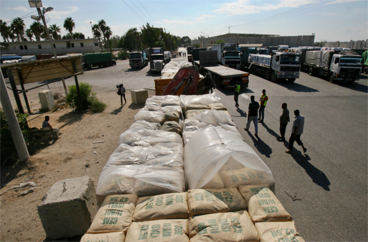 Workers inspect construction material headed into Gaza at the Israel-operated Kerem Shalom crossing into Gaza. Trucks queue up for hours daily, bringing construction and humanitarian supplies into Hamas-controlled Gaza. The Egyptian-run Rafah crossing nearby sits mostly idle. 