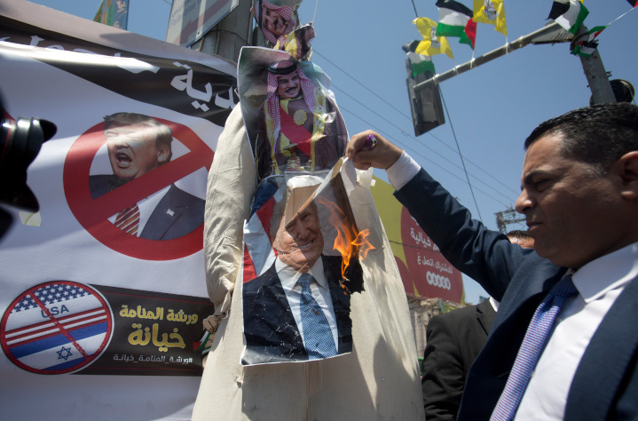 Palestinian near Hebron burns photos of Bahrain’s King Hamad al-Khalifa and President Donald Trump in protest of increasing normalization of relations between Arab nations and Israel, which have been brokered by the United States.