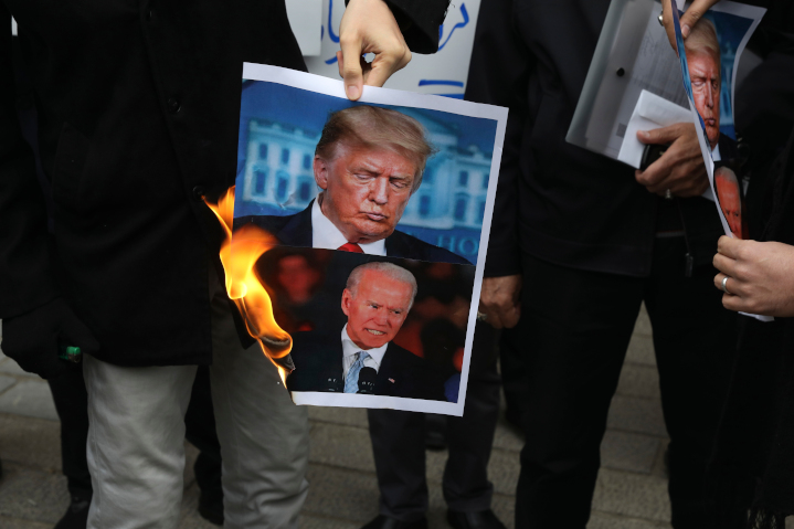 Protestors in front of Iran’s Foreign Embassy in Washington, DC burn photos of Joe Biden and Donald Trump. President-elect Biden says he intends to renew with no preconditions the failed Iran Deal of 2015, which President Trump exited in 2018. Many U.S. allies, such as Israel and Saudi Arabia, fear that a new agreement would increase threats in the Middle East. 