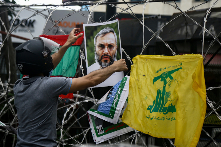During an anti-American protest in Lebanon, a demonstrator hangs a photo of Imad Mughniyeh, who was reportedly killed by collaboration of CIA and Israeli Mossad operatives in Beirut. The Hizbollah commander was long wanted by the U.S. for attacks against U.S. targets in the 1980s.