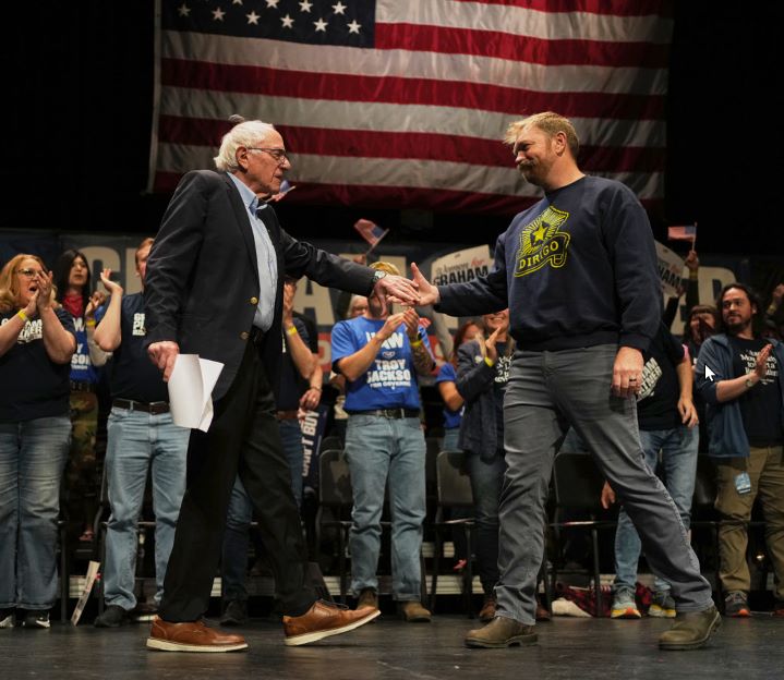Senator Bernie Sanders (D-VT) opposes sale of defensive military weapons to Israel, here greets Maine Democratic Senatorial candidate, Graham Plattner, who sports a Nazi-graphic tattoo and disparages supporters of Israel—two reasons Jewish Democratics are questioning party loyalty. 