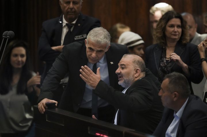 Israel Prime Minister Yair Lapid speaks with fellow member of the Knesset Mansour Abbas, head of the Arab party in Lapid’s governing coalition. Israel’s rank in the 2021 Democracy Index rose to 23rd place globally, partly because Arabs are now included in Israel’s government.