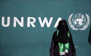 Palestinian woman wearing a green Hamas scarf protests potential U.S. cuts to funding for the United Nations Relief and Welfare Agency (UNRWA), which teaches Palestinian children the virtues of jihad and martyrdom in order to conquer Israel. (AP Photo/Khalil Hamra)