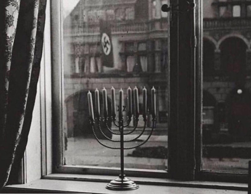 Germany, 1932: A Jewish menorah faces down a Nazi flag. This Hanukkah, we are reminded of 3000 years of Jewish survival, finally to create the State of Israel. Even as our enemies attacks reached a new crescendo at Bondi Beach, still we fight back—and keep our flame burning. 